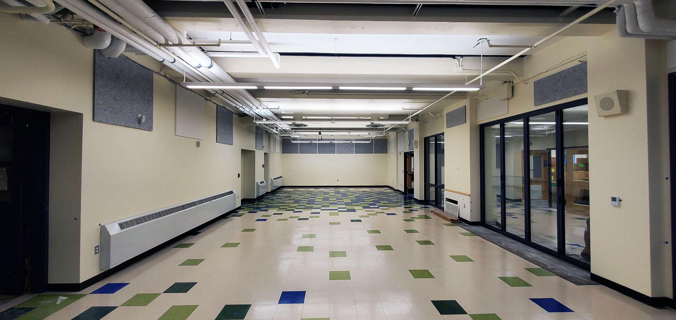 a large empty room has large folding glass doors on one side