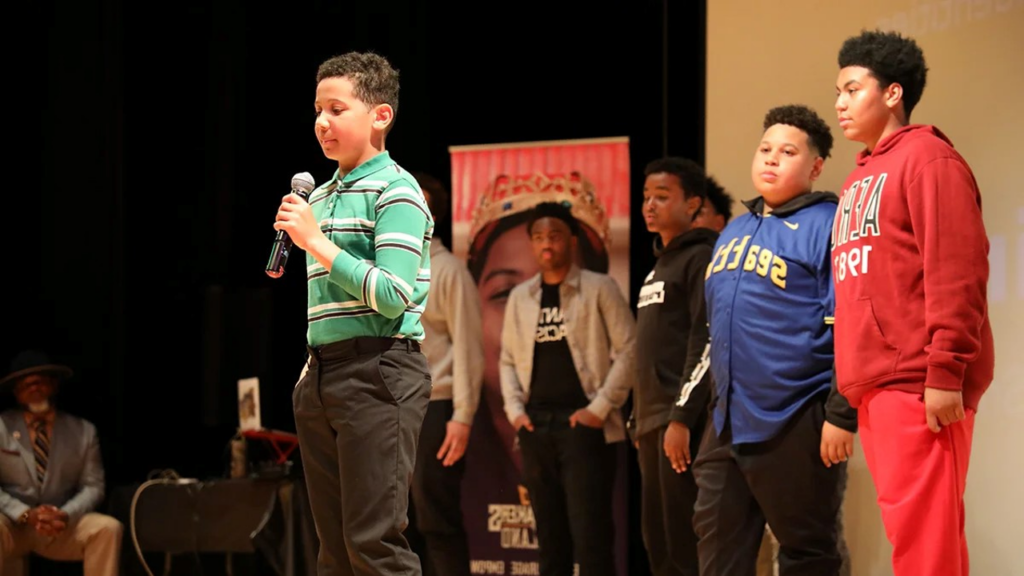 拥护者 学生 with microphone preparing to speak to the audience